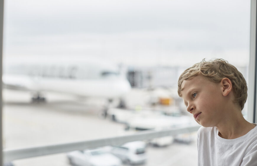 Boy looking out of airport window