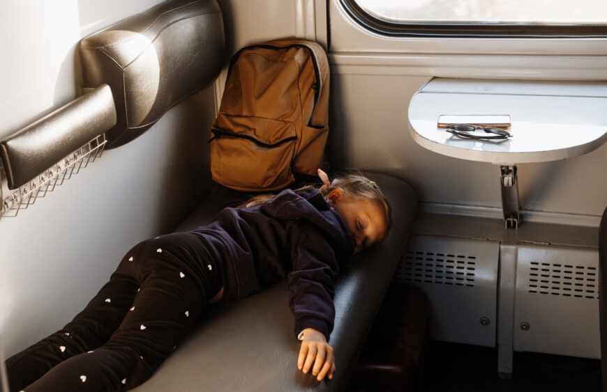 Tired child riding in train. Family travel