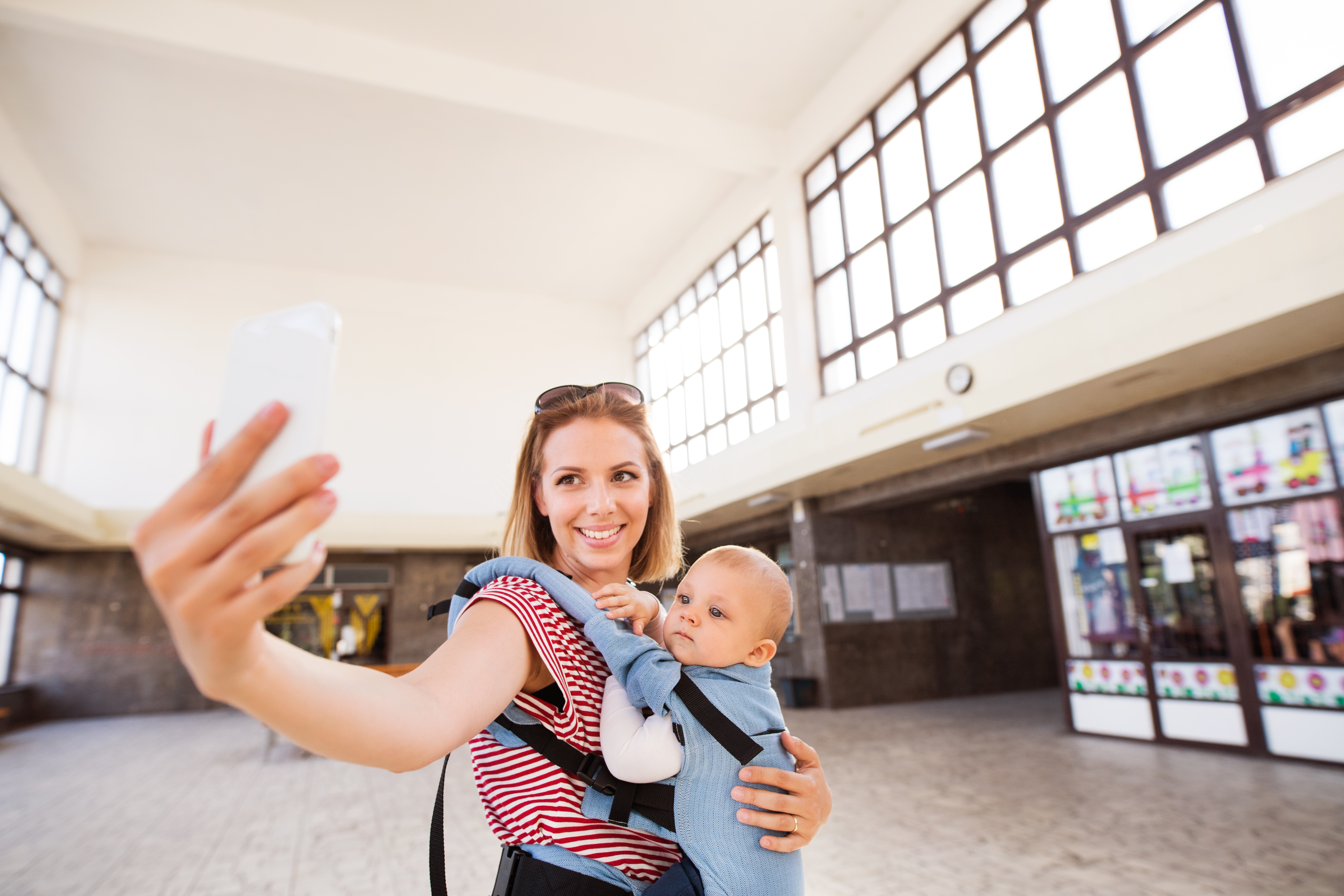 Young mother with smartphone and baby travelling.