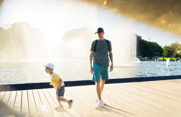 father-and-young-son-walk-near-fountain-water-pla-2025-01-10-04-10-10-utc