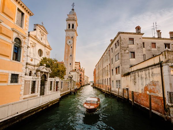typical-venetian-boat-as-it-sails-past-the-church-2024-12-08-05-40-29-utc