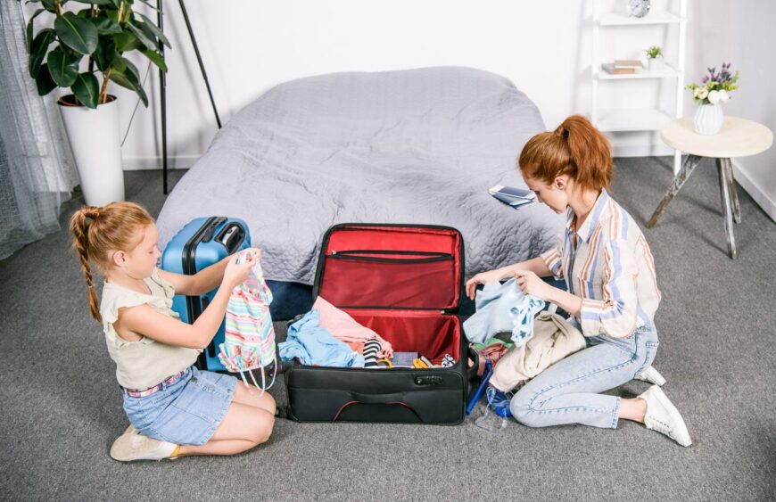young-mother-and-daughter-packing-clothes-for-trip-2024-11-17-16-53-13-utc