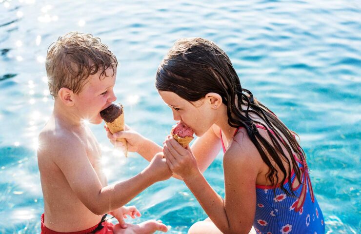 child-sharing-an-ice-cream-by-the-pool-2025-02-10-10-18-20-utc
