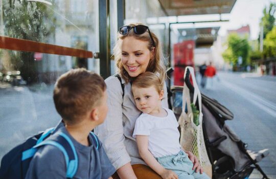 young-mother-with-little-kids-waiting-on-bus-stop-2024-10-20-08-55-58-utc