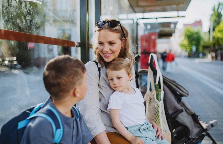 young-mother-with-little-kids-waiting-on-bus-stop-2024-10-20-08-55-58-utc