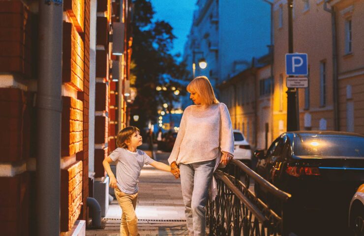 mother-and-son-walking-outside-on-old-city-street-2024-12-02-08-00-11-utc