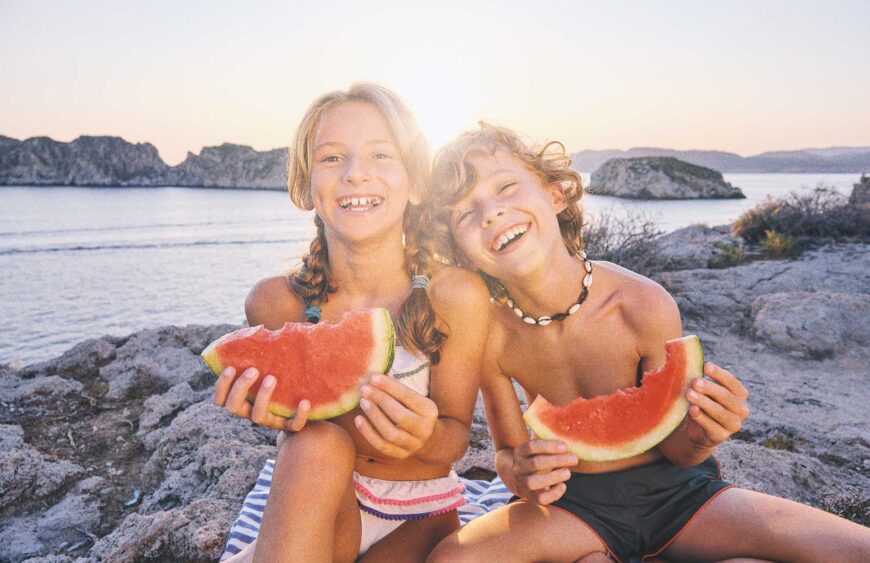 smiling-children-with-watermelon-slices-on-coast-n-2025-04-03-00-45-00-utc