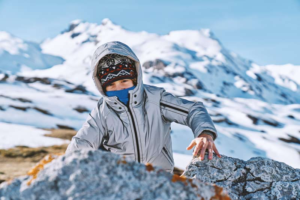 switzlernand_boy-climbing-on-rock-in-snowy-mountains