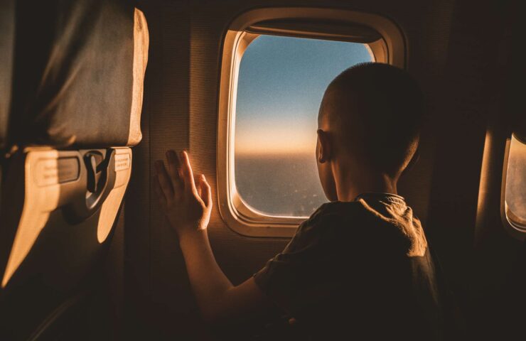 rear-view-of-a-boy-in-airplane-looking-through-the-2026-06-24-03-58-30-utc