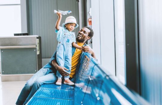 cheerful-toddler-with-toy-airplane-with-and-father